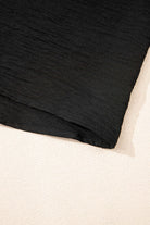 Close-up of the hem of the black Oasis Moment 2 Piece Pants Set, showcasing its textured fabric and relaxed design.