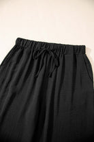 Close-up of black drawstring wide-leg pants from the Oasis Moment 2-piece set, showcasing soft fabric and relaxed fit.