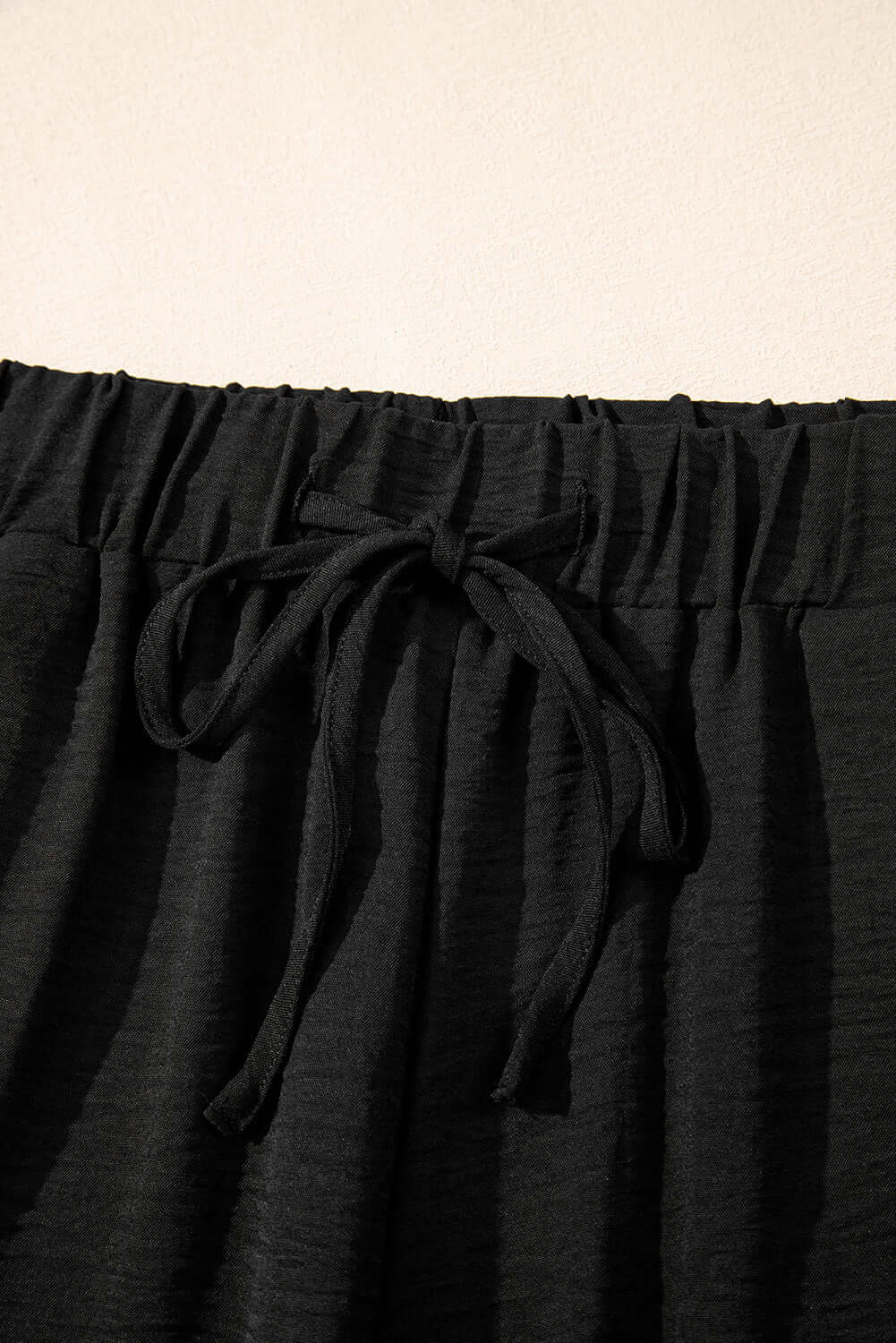 Close-up of black wide-leg pants waistband with drawstring detail from the Oasis Moment 2 Piece Set.