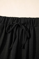 Close-up of black wide-leg pants waistband with drawstring detail from the Oasis Moment 2 Piece Set.