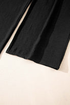 Close-up of black wide-leg pants from the Oasis Moment 2 Piece Pants Set on a light background.