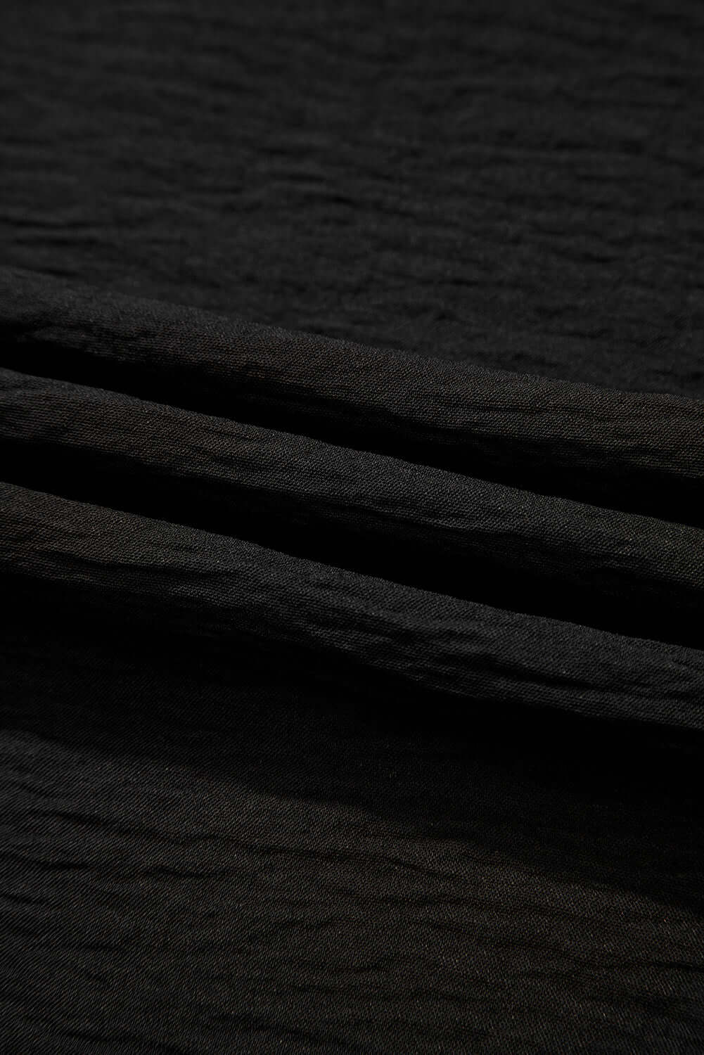 Textured black fabric showcasing the material of the OASIS MOMENT 2 Piece Pants Set.