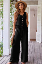 Oasis Moment 2-piece black pants set featuring a buttoned crop vest and wide-leg pants in a stylish outdoor setting.