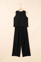Oasis Moment 2 Piece Pants Set in black featuring a buttoned vest and wide-leg pants, styled elegantly on a hanger.