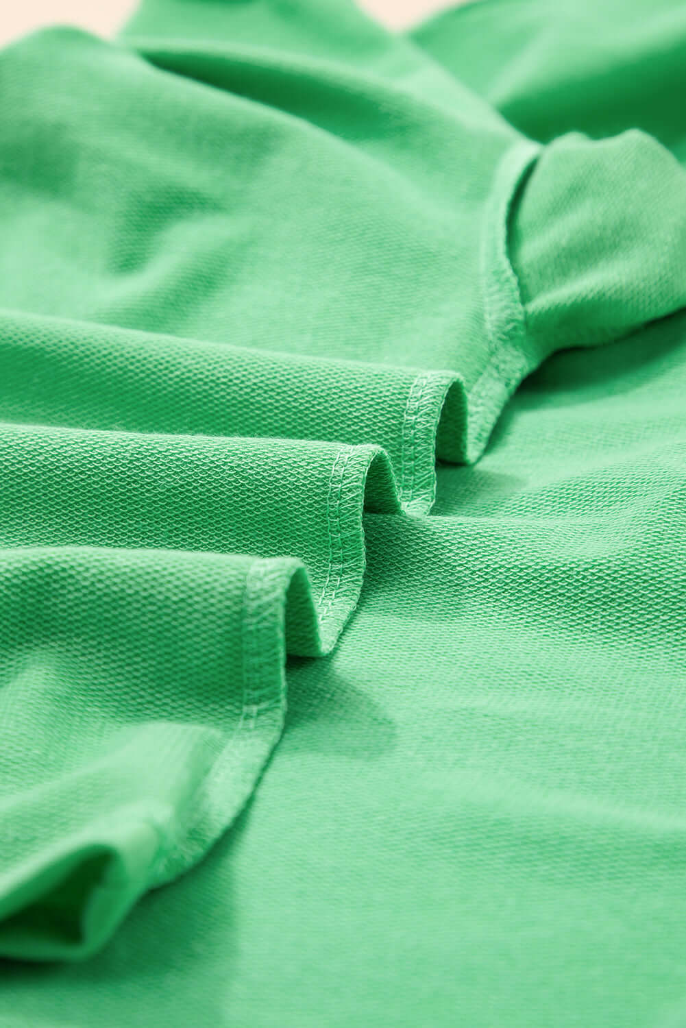 Close-up of vibrant green fabric showcasing the relaxed fit of a V-neck tee from the Zest for Life shorts set.