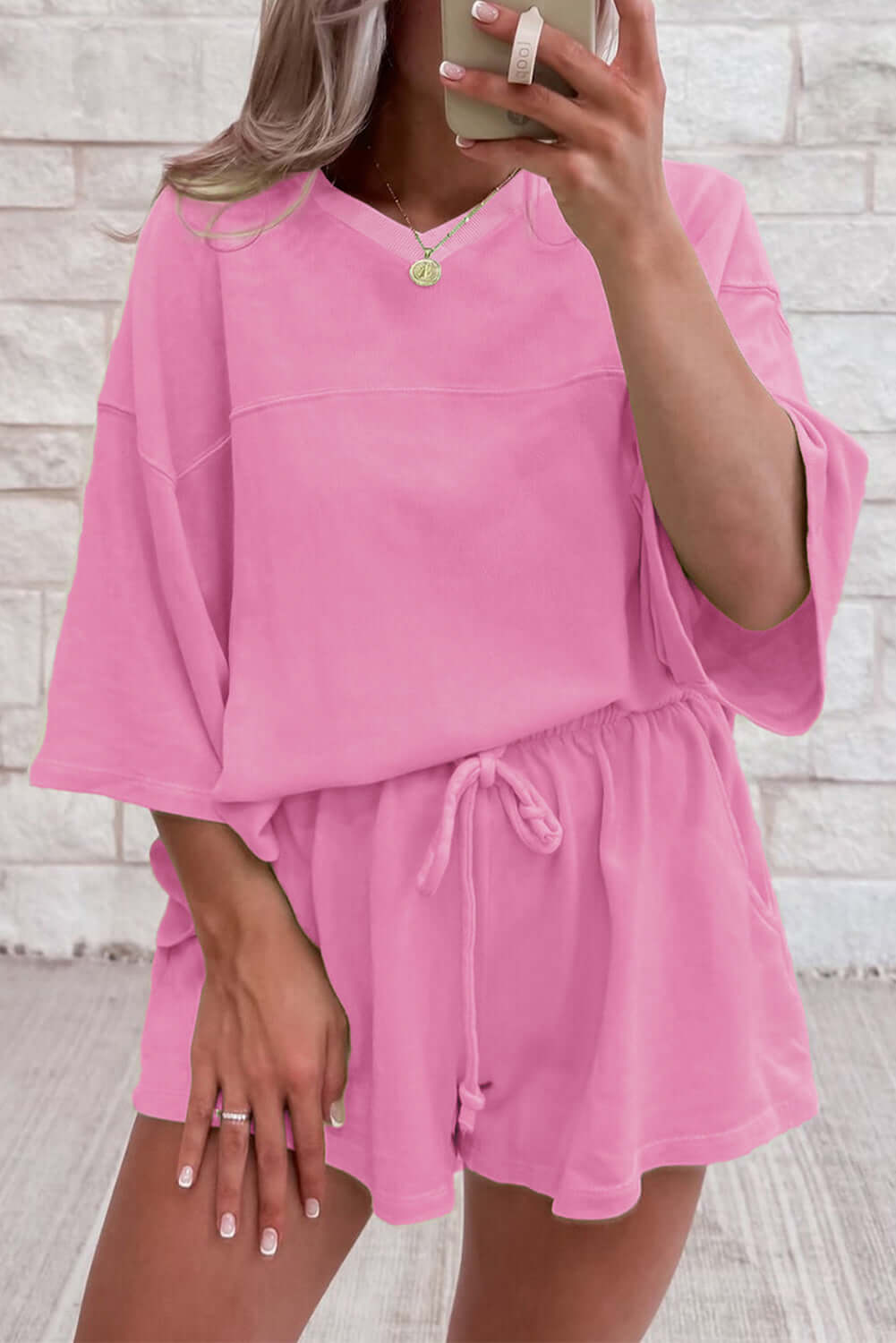 Woman in bonbon pink Barefoot Bliss Set, featuring oversized top and relaxed-fit shorts, perfect for casual lounging.