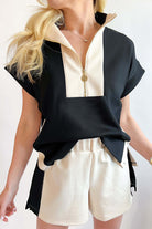 Black and cream colorblock Monochrome Motion shorts set with zip collar top and side slits.