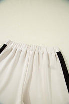 Elastic waist shorts with black and cream colorblock design for sporty chic style.