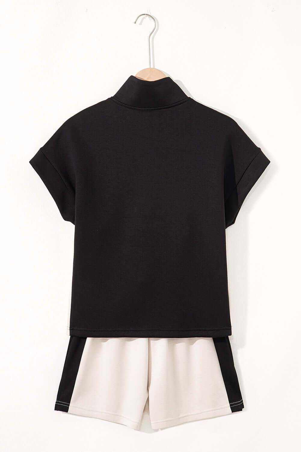 Back view of the METRO MODE monochrome shorts set featuring a zip collar top and cream-colored shorts.