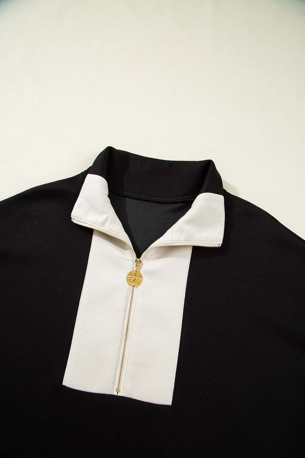 Black and cream zip collar top from the METRO MODE SHORTS SET, showcasing chic sporty style.