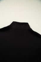 Close-up of the zip stand collar on a black top from the METRO MODE SHORTS SET, showcasing sleek design.