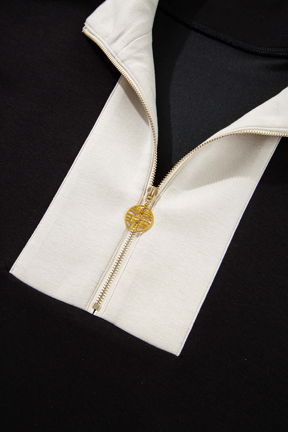 Close-up of the zip collar of a Monochrome Motion Set in black and cream, showcasing chic sporty style.