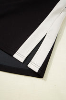 Close-up of Monochrome Motion Set showing zip collar and side slits in black and cream colorblock design.