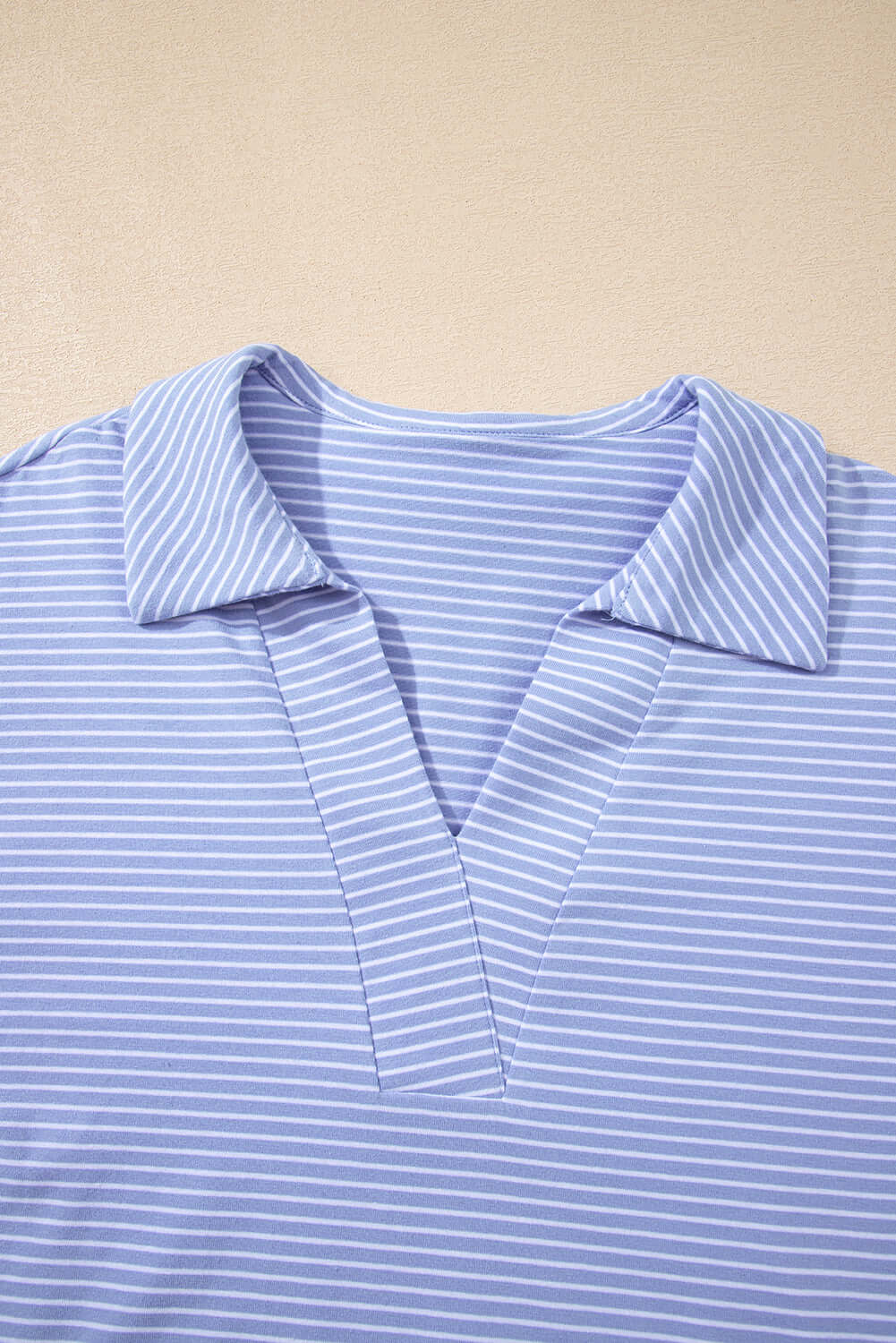 Close-up of Misty Harbor sky blue polo top with vertical stripes and a classic collar, perfect for casual outfits.