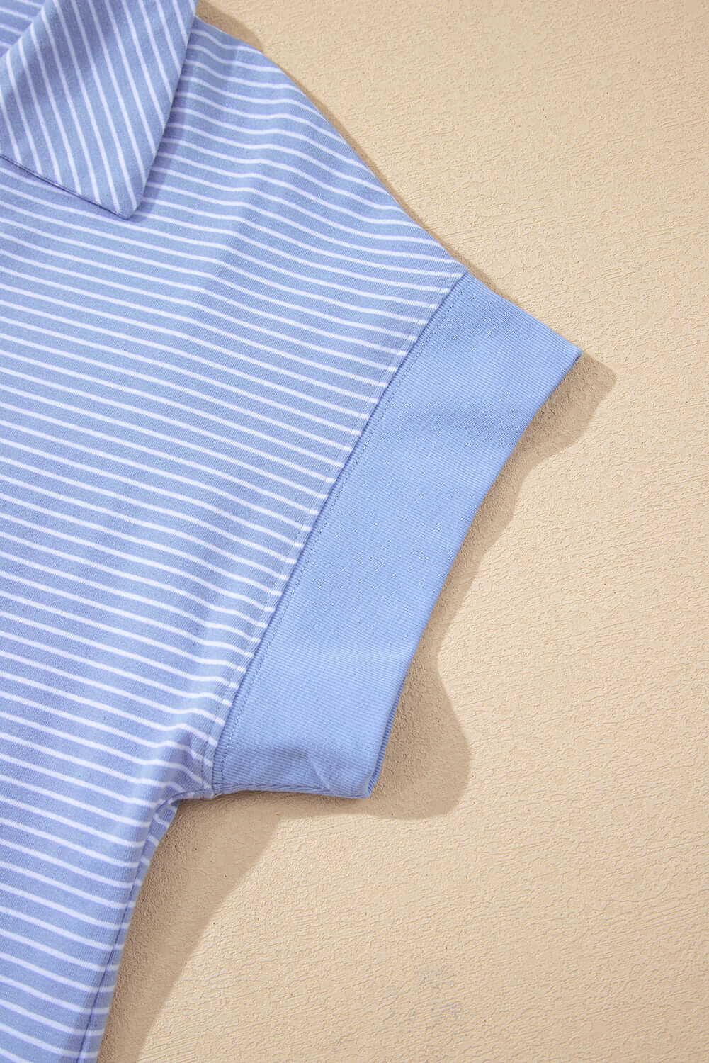 Close-up of sky blue striped polo top collar and sleeve of Misty Harbor 2-Piece Shorts Set.