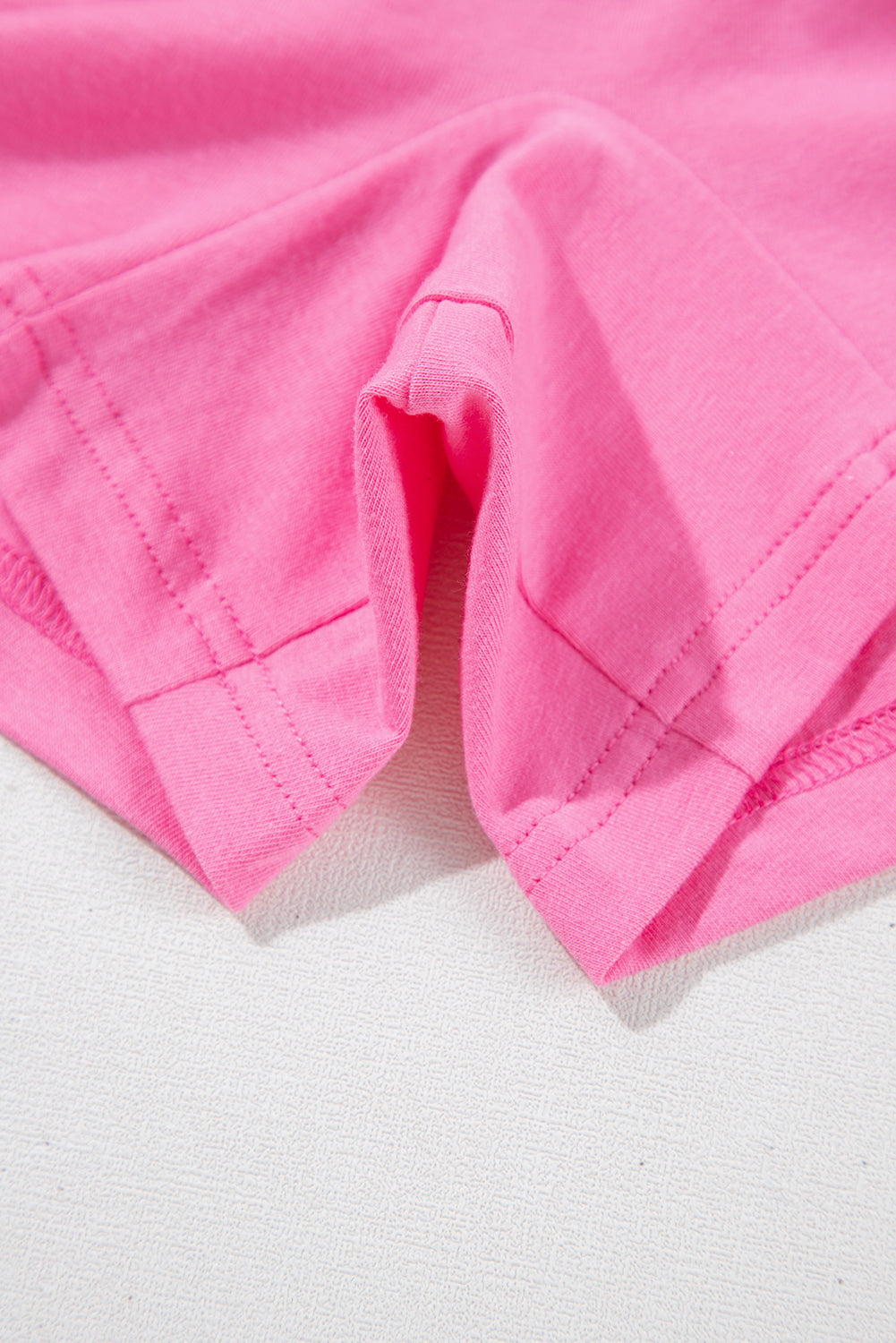 Close-up of soft, pink fabric highlighting the relaxed fit and rolled cuffs of the Dream Daze Romper.