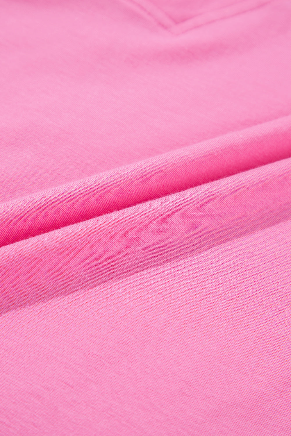 Soft strawberry pink fabric close-up, showcasing the dreamy texture of the Dream Daze Romper.