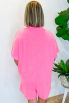 Back view of a woman in a soft, stylish strawberry pink romper for casual and comfortable wear.