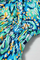 Close-up of the Wave Dancer Romper showing the colorful green and blue abstract print and gathered waist.