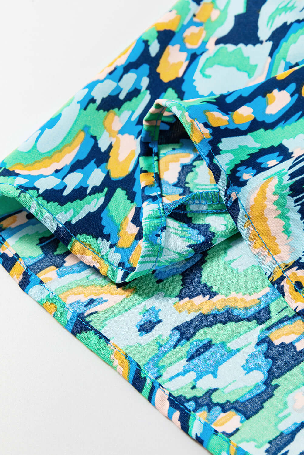 Close-up of the Wave Dancer Romper's green and blue abstract print fabric with puff sleeve detail.