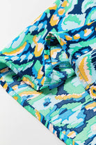 Close-up of the Wave Dancer Romper's green and blue abstract print fabric with puff sleeve detail.