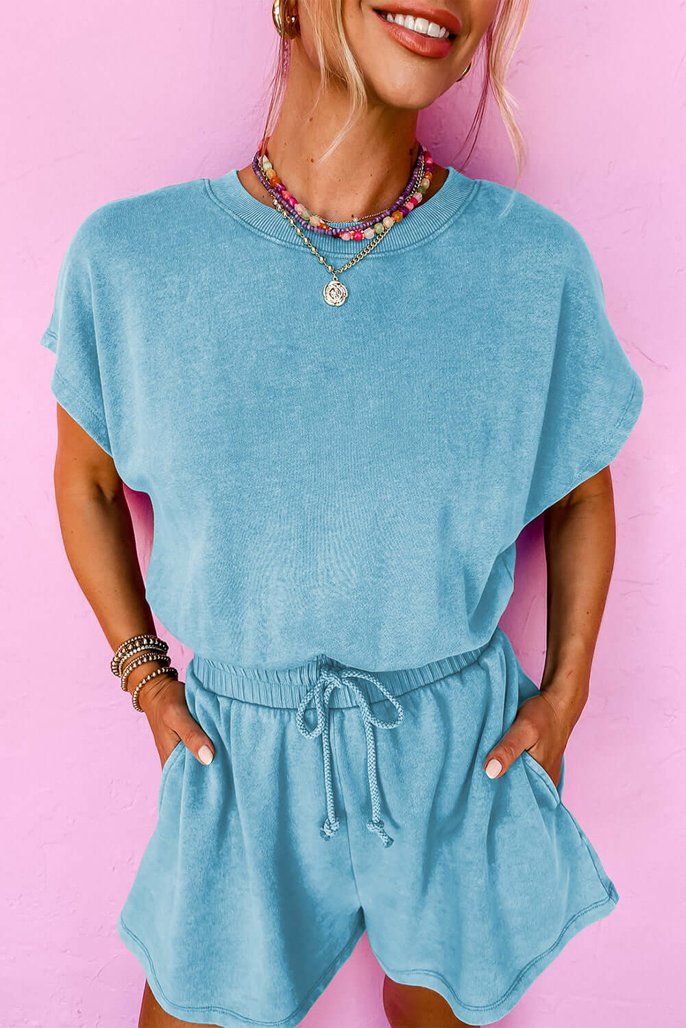 Chill Factor Romper in sky blue, featuring short sleeves, elastic waist, pockets, and playful back detail.