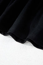 Detail of Eclipse Edge Skort showing the black fabric and ruched hem for a sleek activewear look.