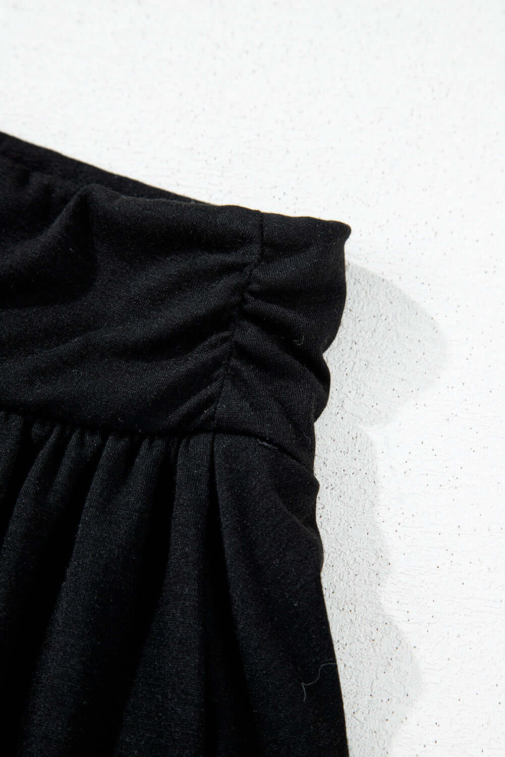 Close-up of the ruched waistband on the black Eclipse Edge Skort, showcasing its sleek design and comfortable fit.