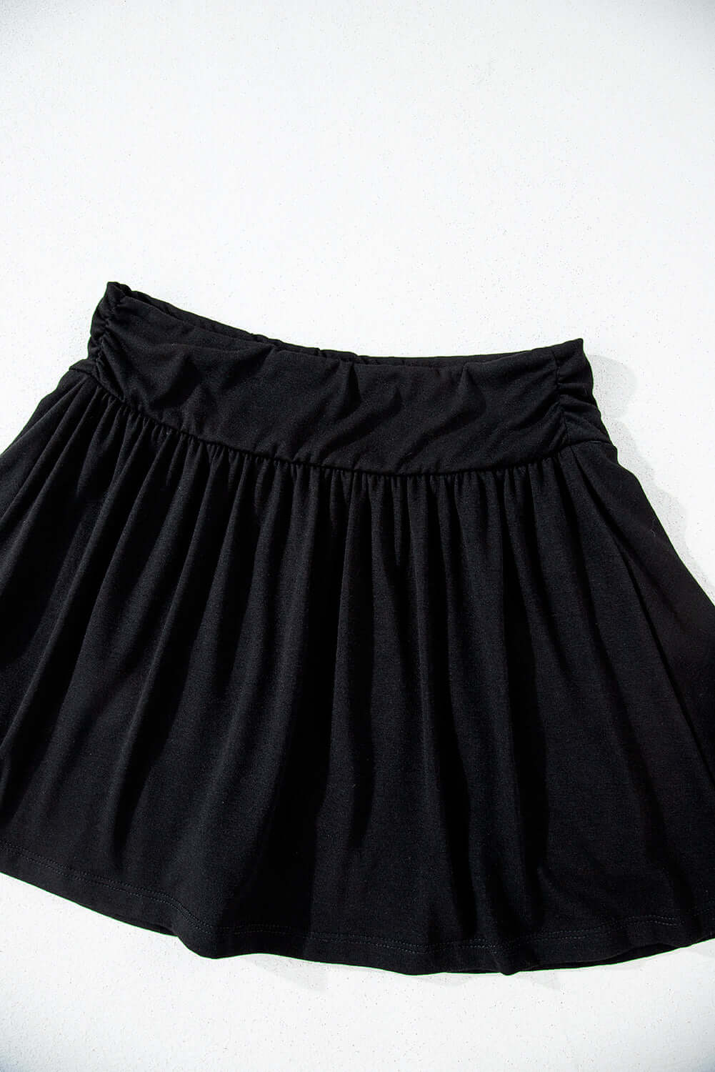 Eclipse Edge Skort featuring a black wide waistband and flattering ruched design, perfect for activewear.