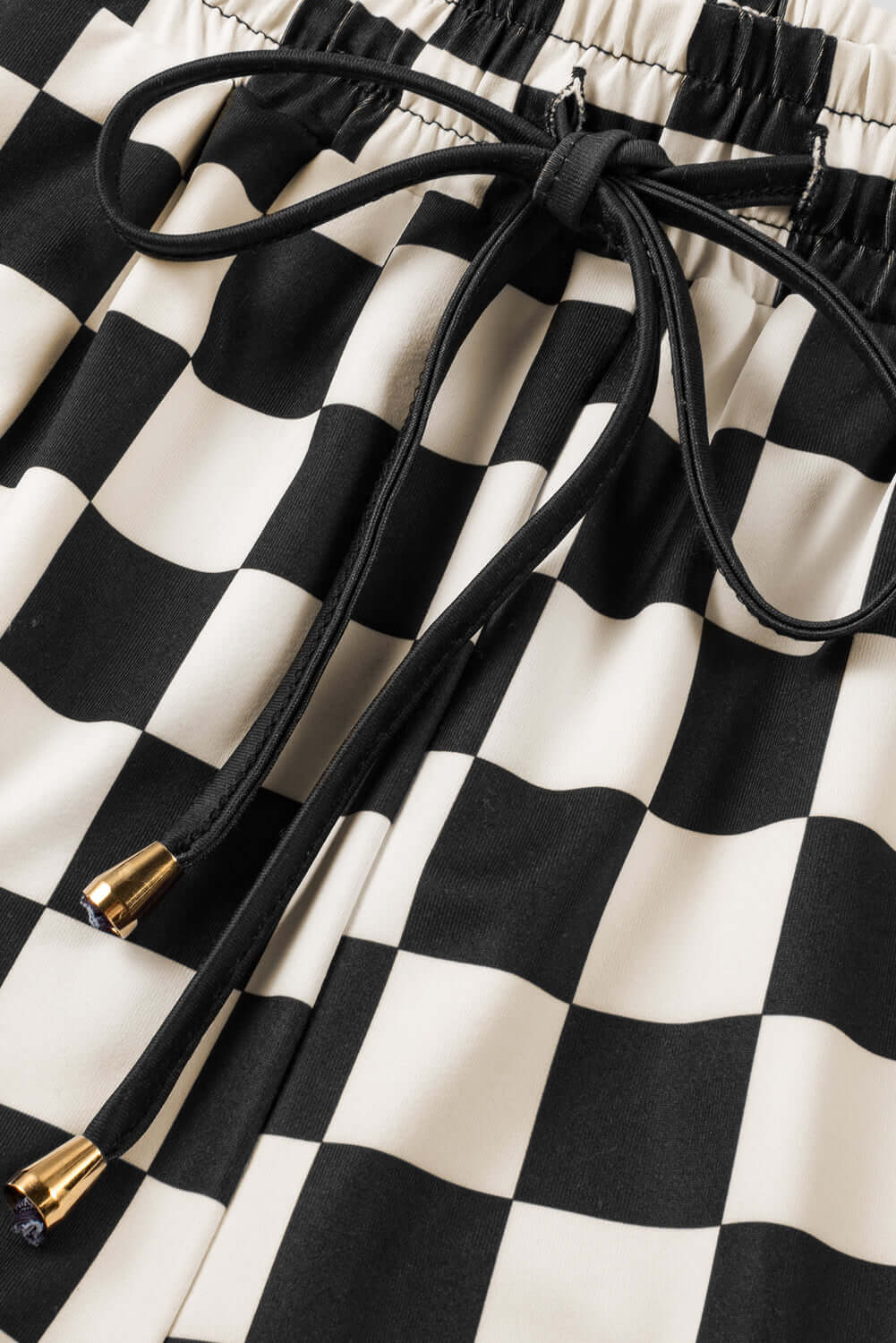 Close-up of Fast Lane Shorts featuring black checkered pattern and drawstring detail for casual style.