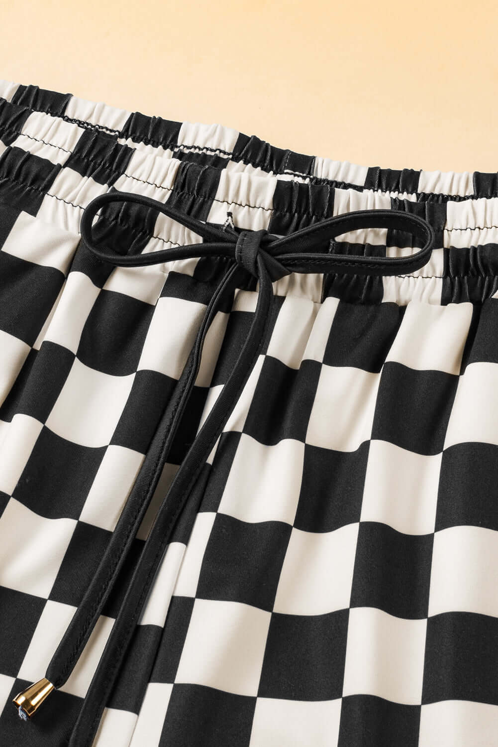 Close-up of black and white checkered Fast Lane Shorts with drawstring detail.