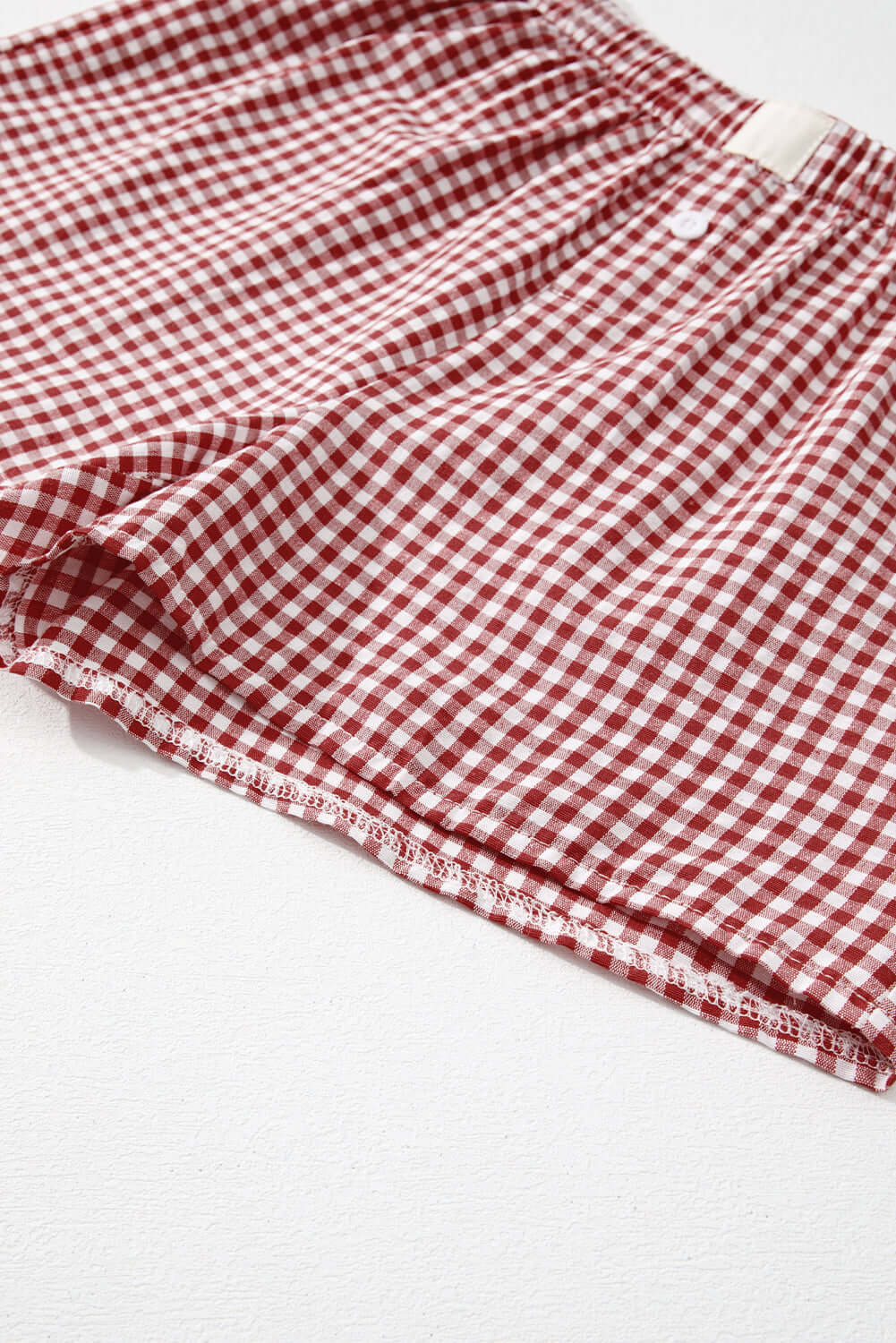 Red gingham shorts with an elastic waistband, ideal for a stylish and comfortable summer picnic.