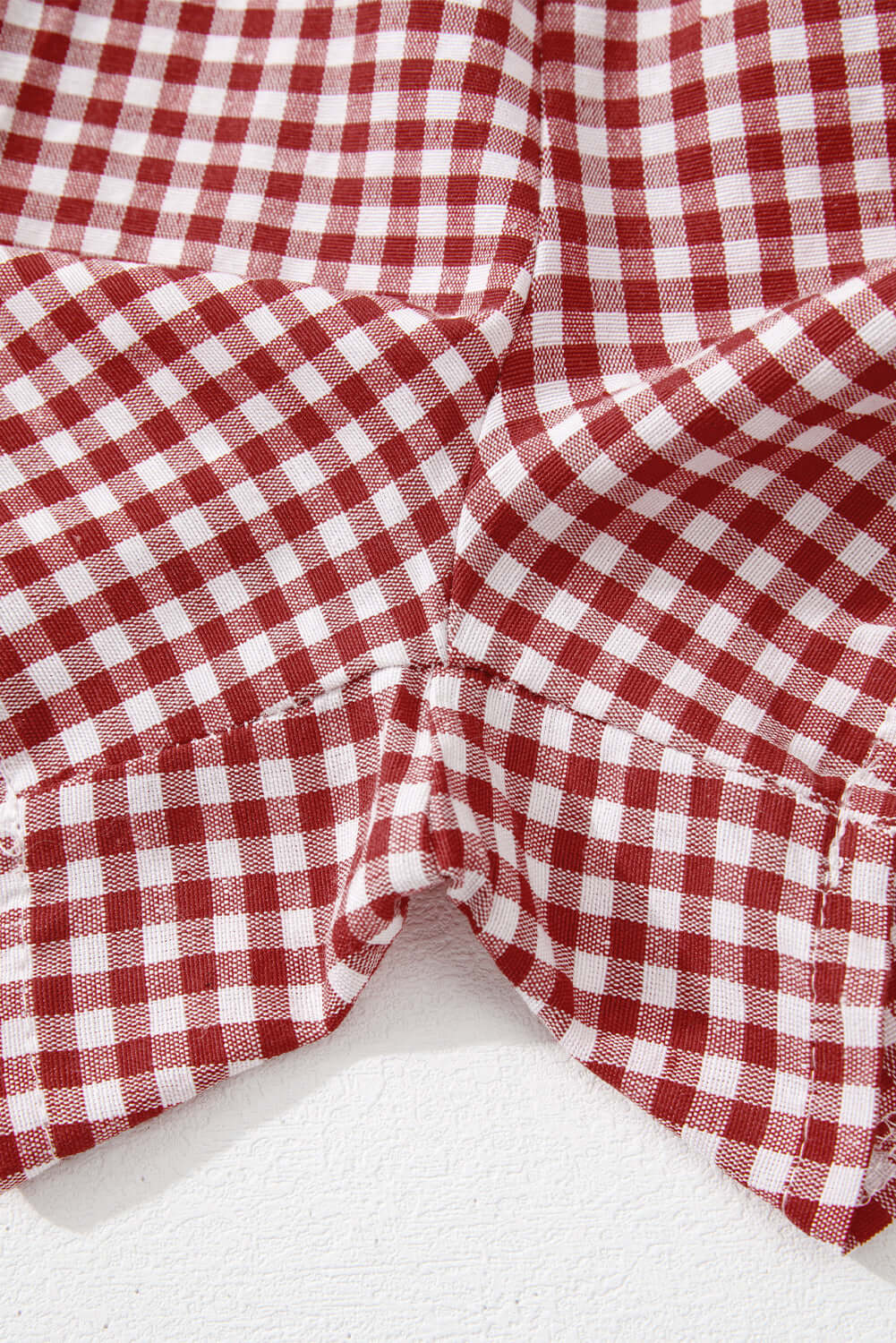 Red gingham fabric detail of high waist Picnic Perfect Shorts, showcasing elastic waistband and stylish design.