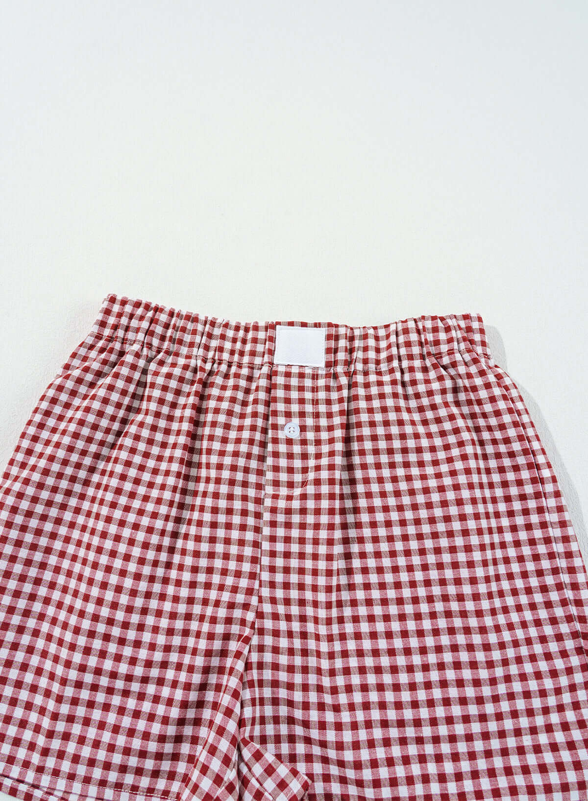 Red gingham high waist shorts with elasticated waistband and button fly detail, perfect for sunny picnic days.