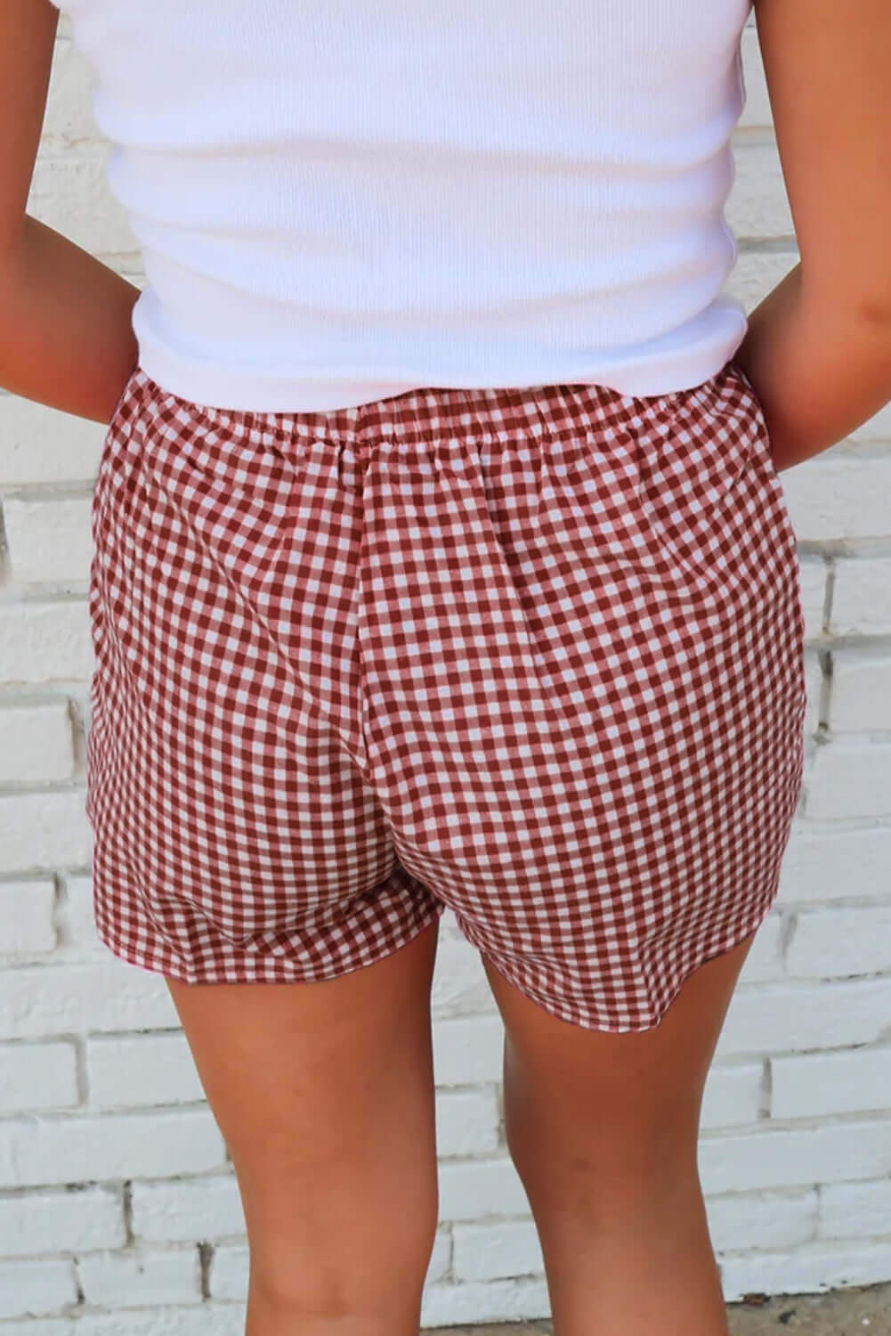 Red gingham high waist shorts with elastic waistband, perfect for a sunny picnic day.
