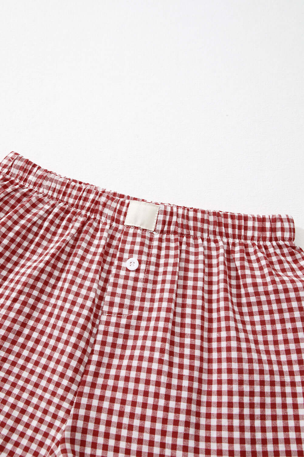 Red gingham high waist shorts with elastic waistband and button fly detail for stylish comfort.