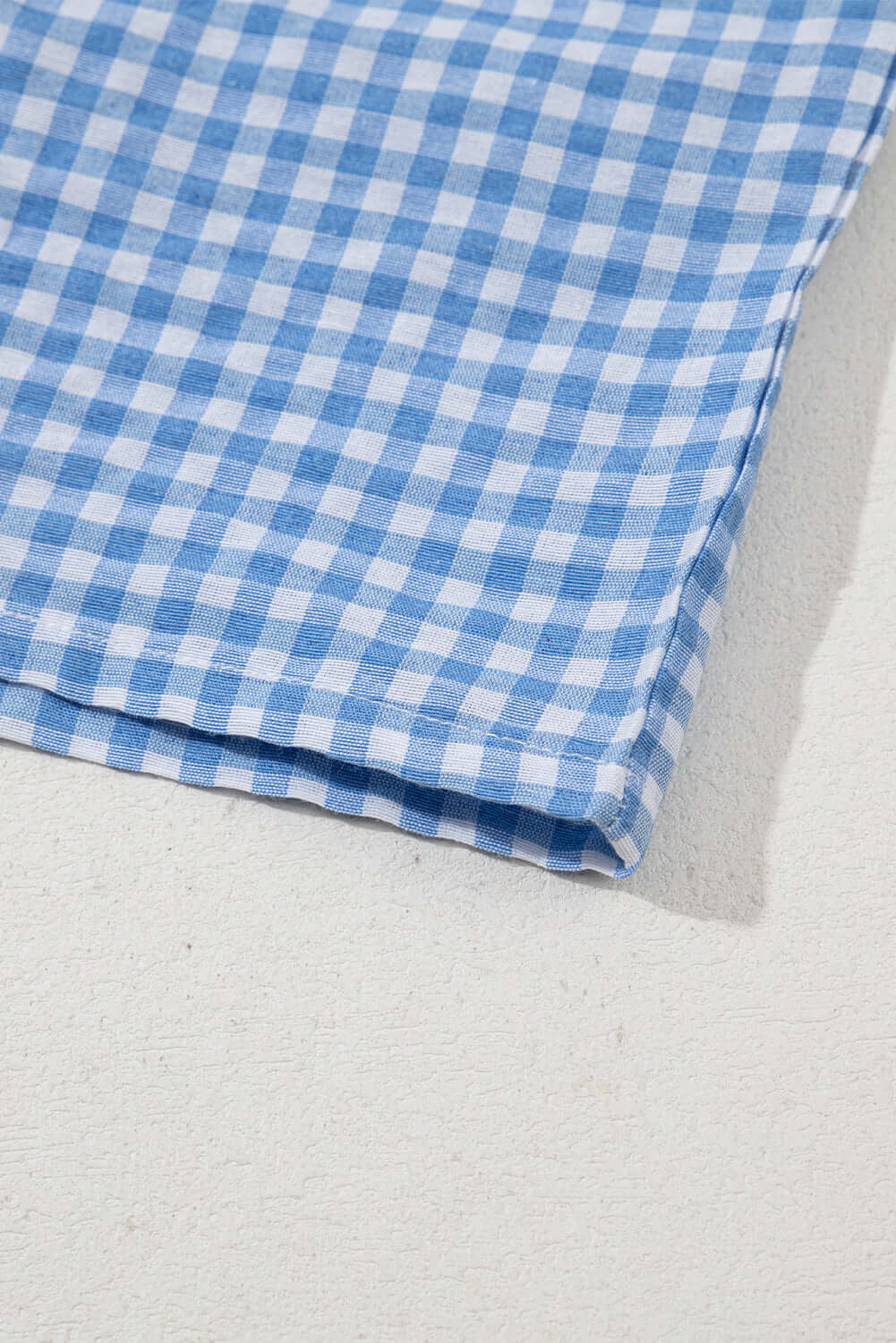 Blue gingham fabric close-up showcasing the Picnic Perfect Shorts' stylish design.
