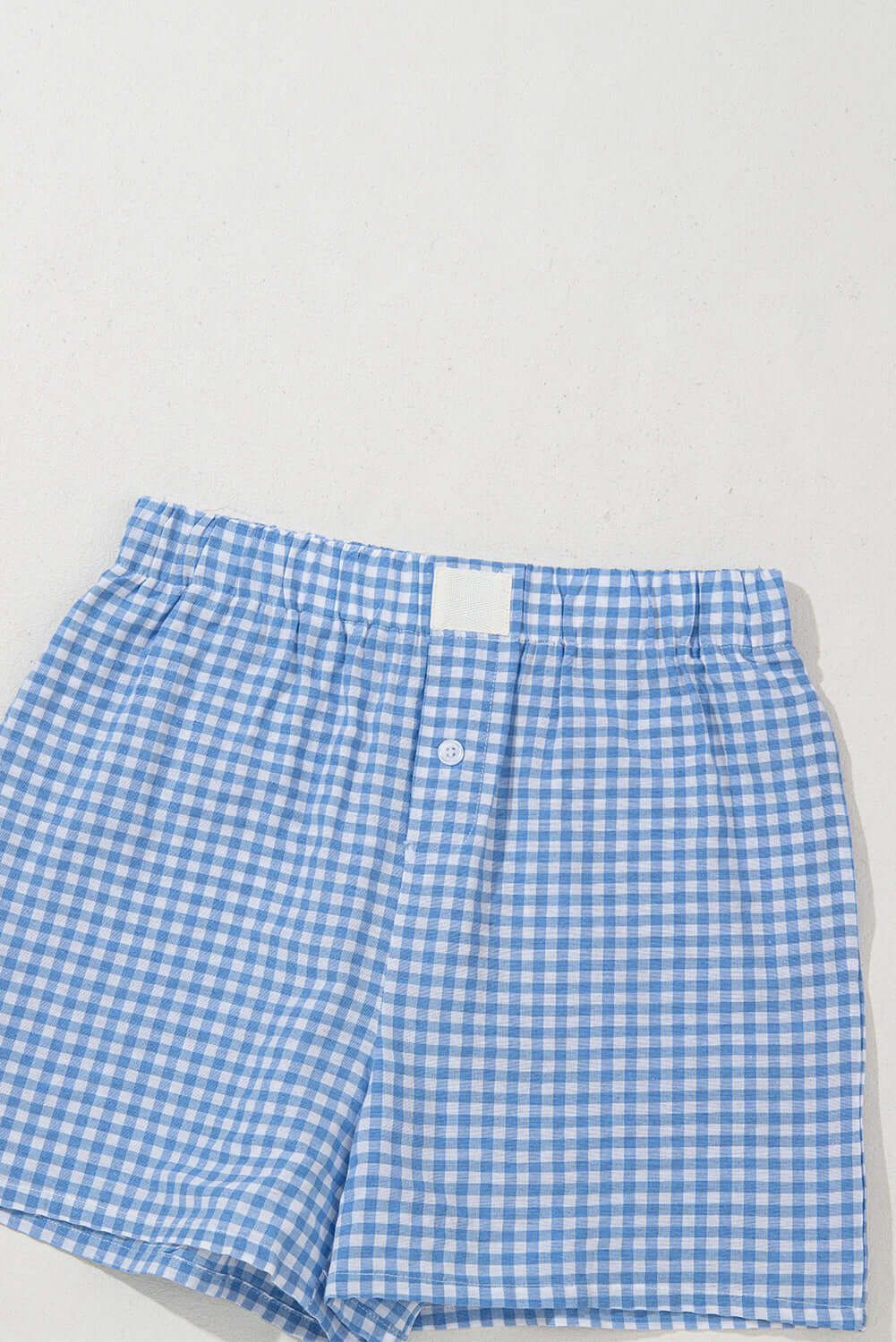 Blue gingham shorts with high waist and button fly, perfect for summer picnics and casual outings.