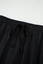 Close-up of the high-waisted drawstring waistband on a black skort, showcasing its sporty and stylish design.