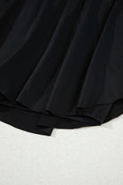 Close-up of the Twilight Tempo Skort showcasing its flowy black fabric and layered design for sporty elegance.