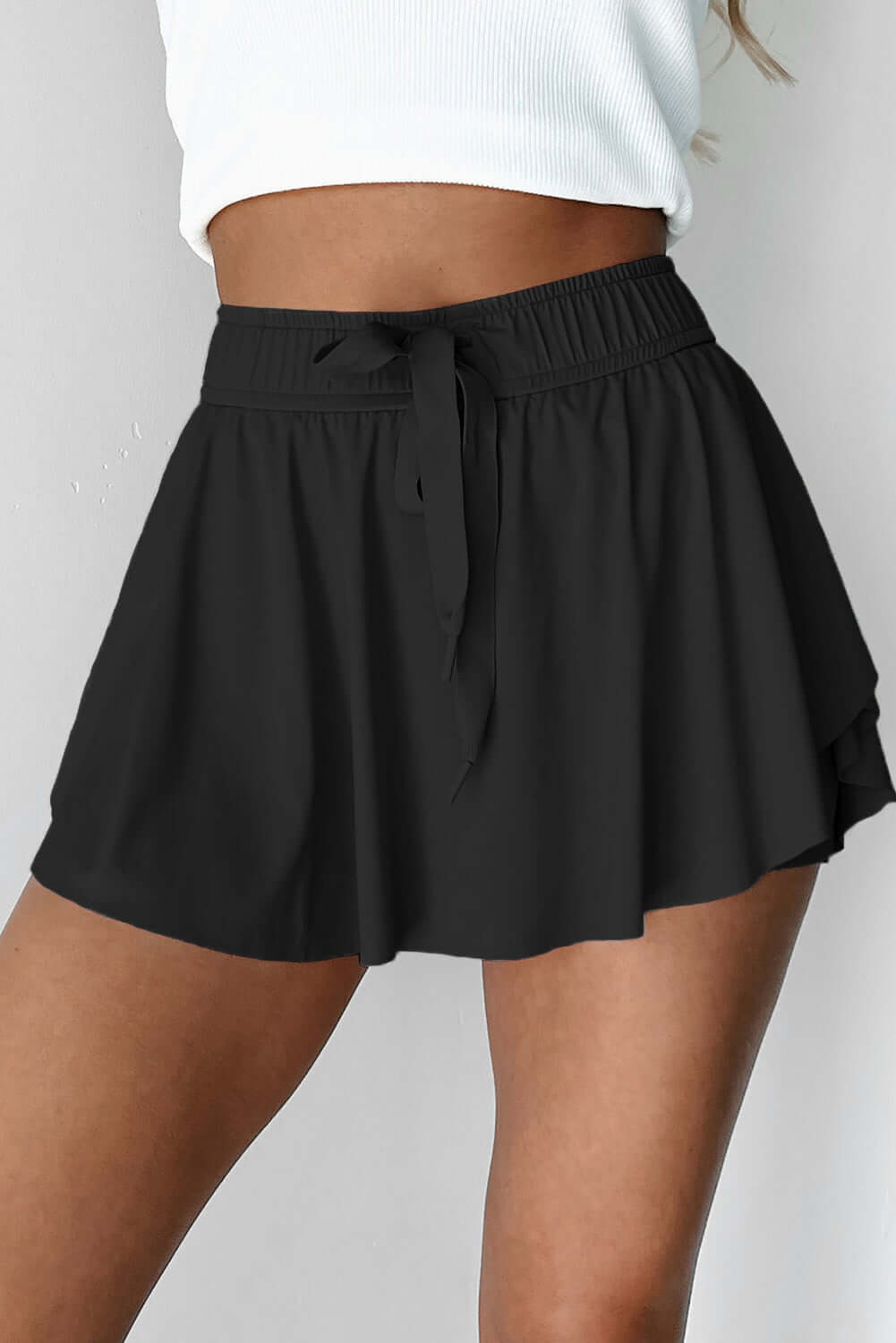 Black Twilight Tempo Skort with a stretchy waistband and flowy overlay for sporty and stylish looks.