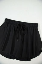 Black high-waisted skort with a stretchy waistband and flowy overlay, perfect for sporty and casual wear.