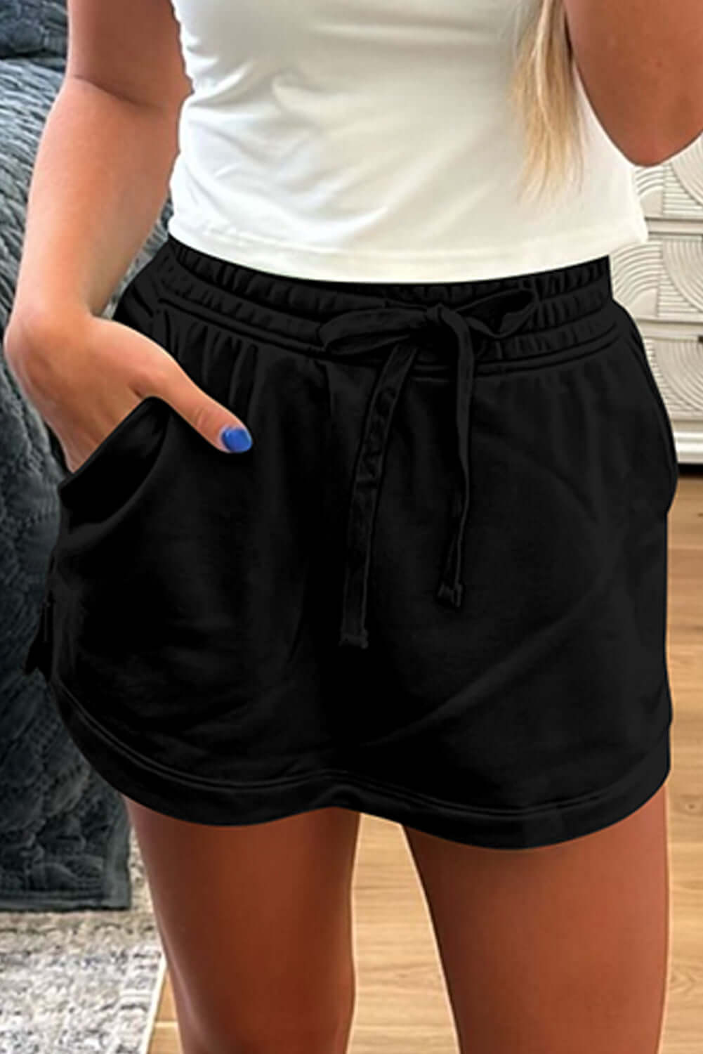 Black French terry skort featuring a drawstring waist and side pockets for casual comfort.