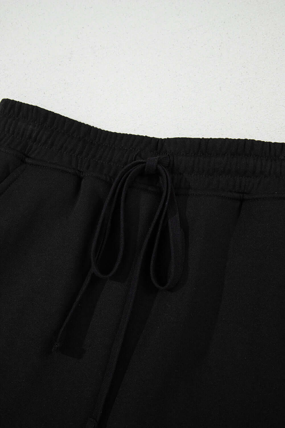Black French terry mini skort with adjustable drawstring waist, perfect for casual outings and comfort.