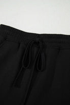 Black French terry mini skort with adjustable drawstring waist, perfect for casual outings and comfort.