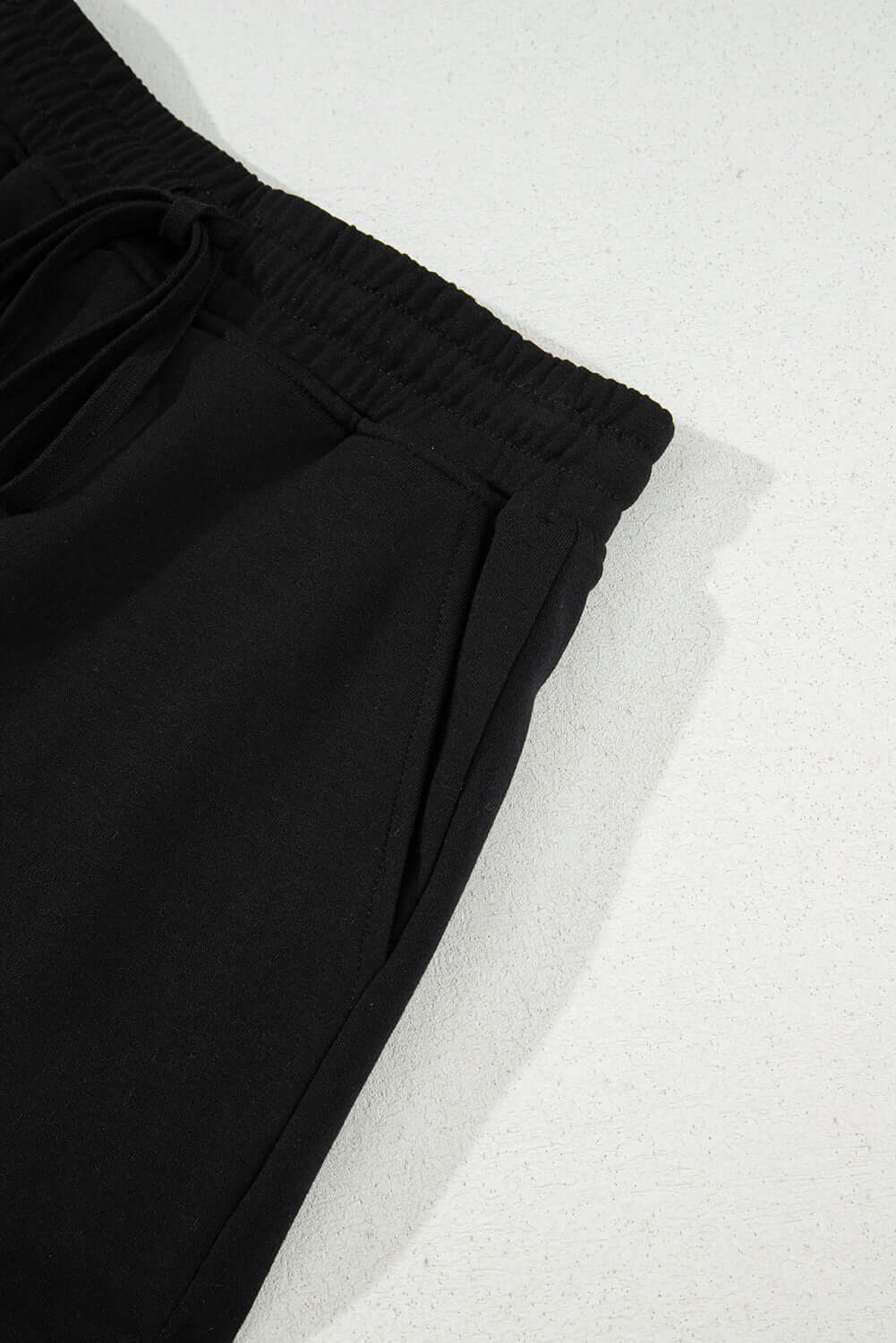 Close-up of a black French terry drawstring skort, showcasing the soft fabric and elastic waistband.