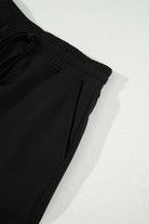 Close-up of a black French terry drawstring skort, showcasing the soft fabric and elastic waistband.