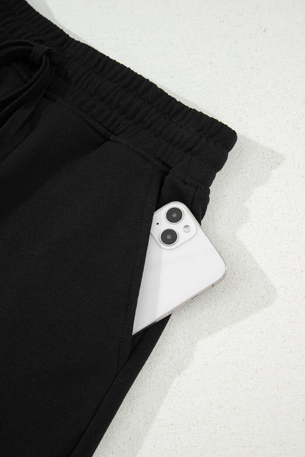 Black French terry skort with a smartphone in the pocket, showcasing comfort and practicality.
