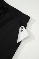Black French terry skort with a smartphone in the pocket, showcasing comfort and practicality.