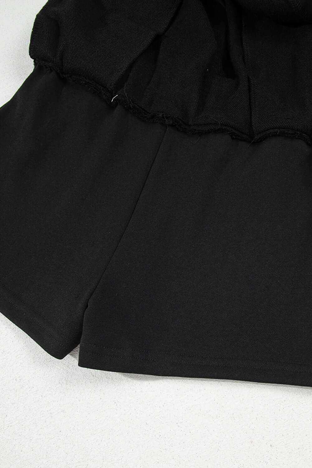 Black French terry skort featuring a drawstring waist and stylish mini skirt design.